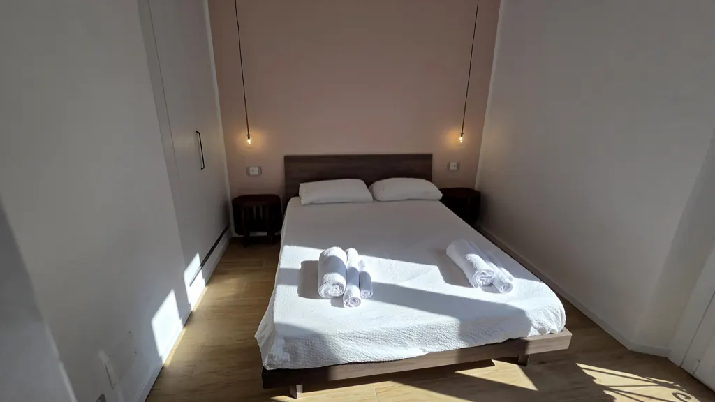 Camera matrimoniale dell'appartamento Stay Navigli, letto 160×200 con materasso Dorelan e luci sospese